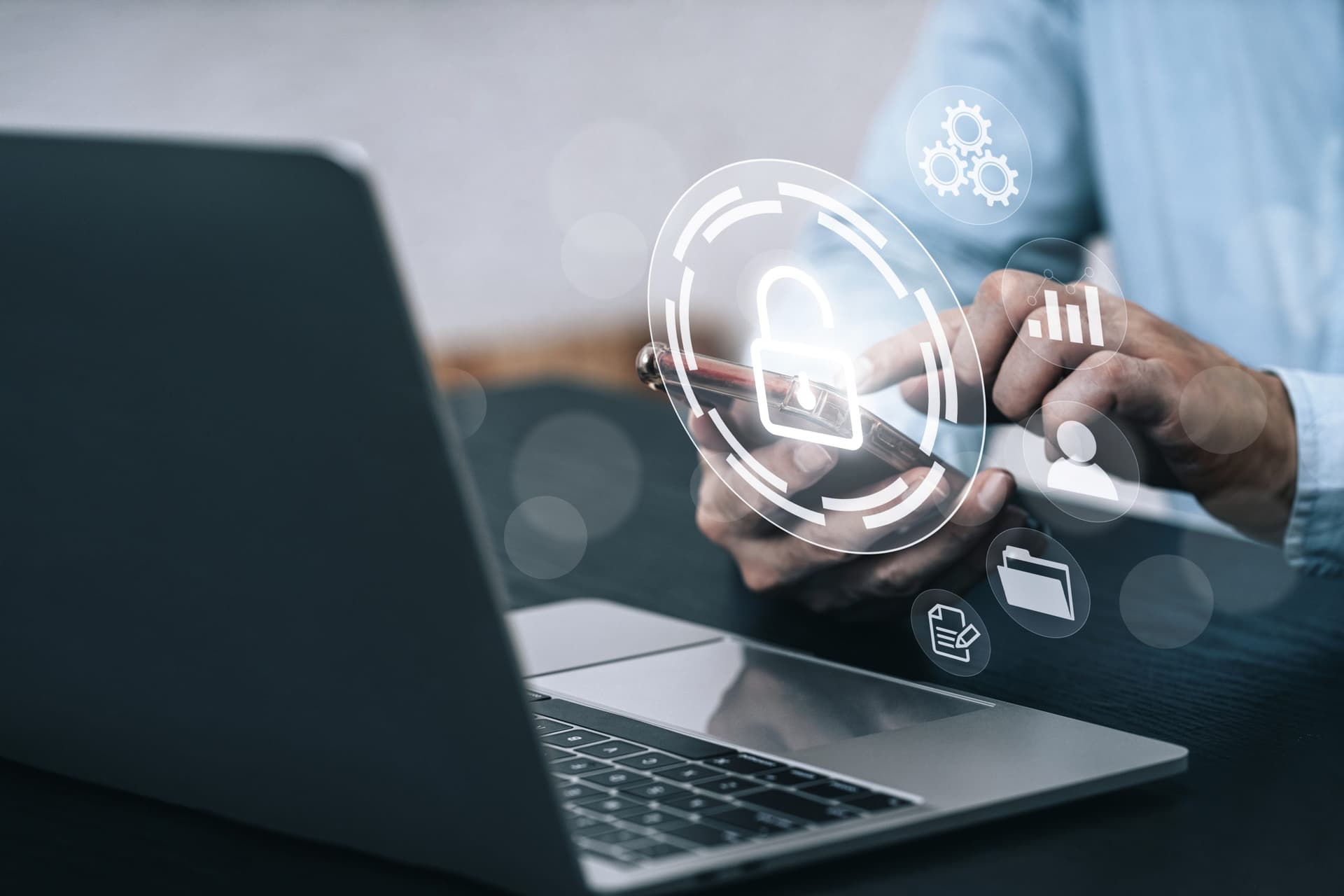 Person using a smartphone with a laptop in the foreground, overlaid with icons representing security, data management, and cloud backup.