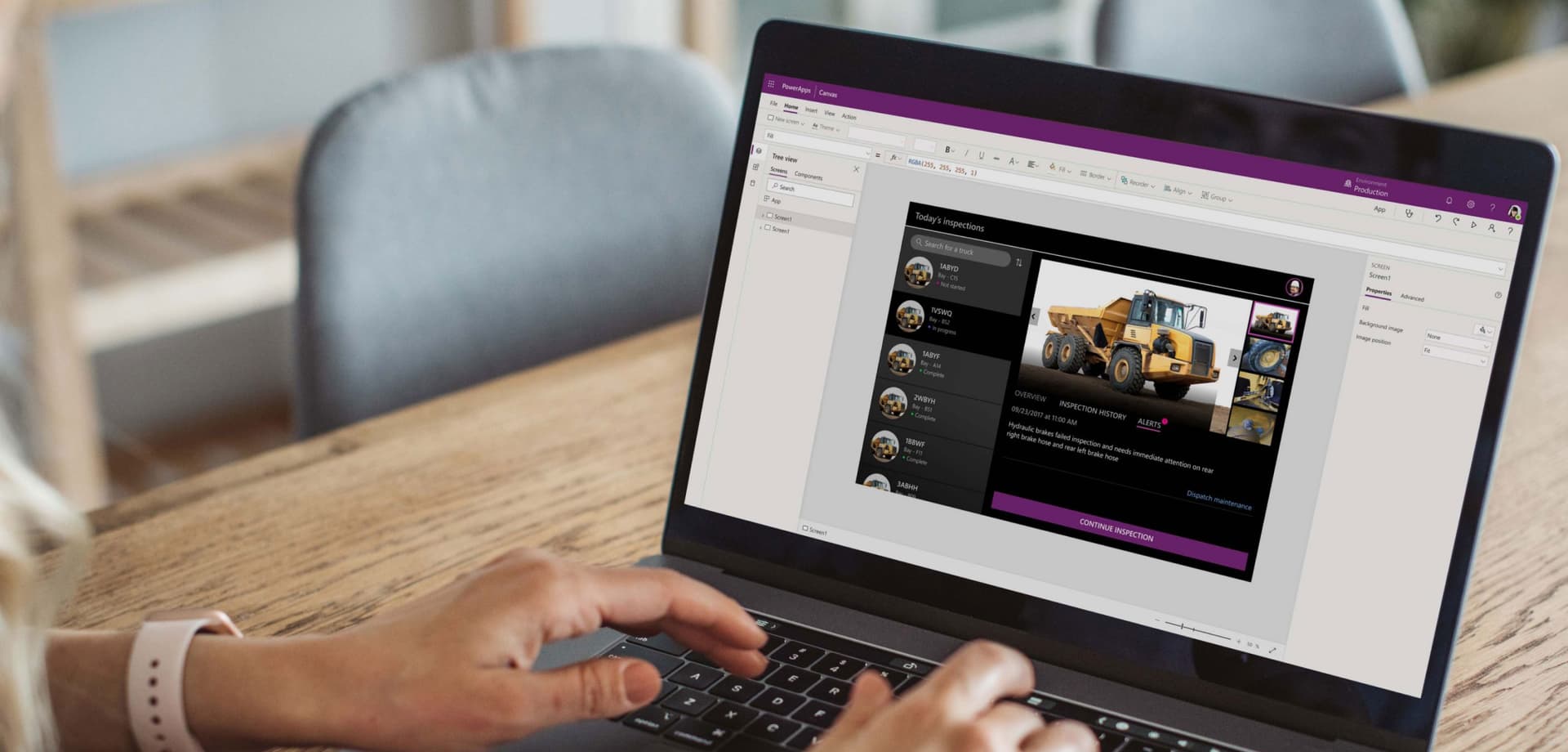 Person using a laptop with Microsoft Power Apps interface visible