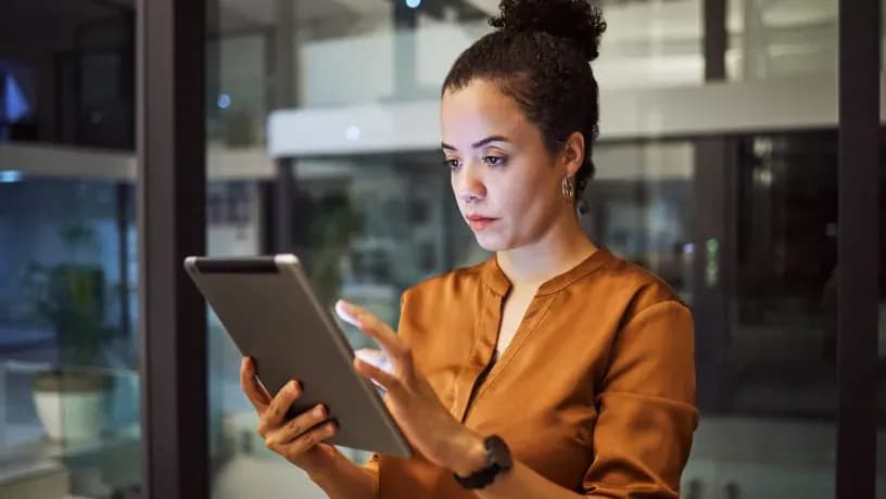 Person interacting with a tablet device, representing the use of adaptive technology in incident management.