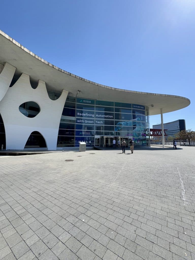 Modern building with large windows and a banner reading ‘Redefining Automation with Green Tech.’